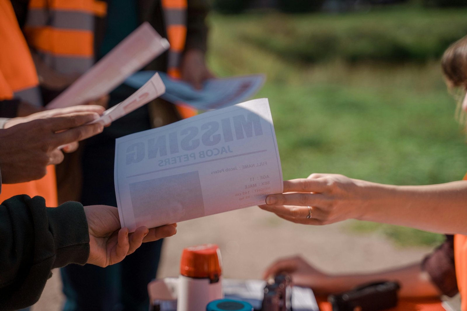 Elite Investigation & Protection for Legal Professionals, Insurance Carriers, and Private Individuals. Group of volunteers handing out missing person flyers during a search operation outdoors.